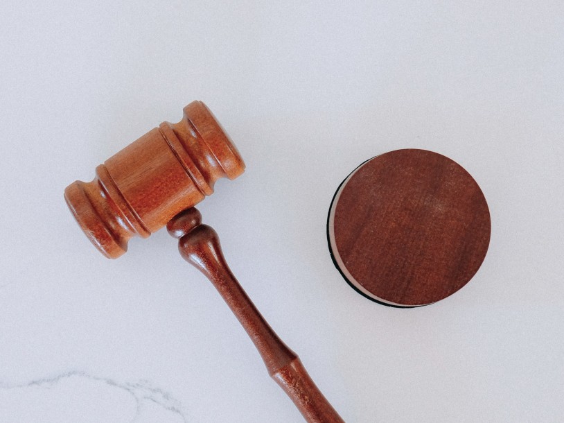 Drewniany młotek sędziowski na białym tle